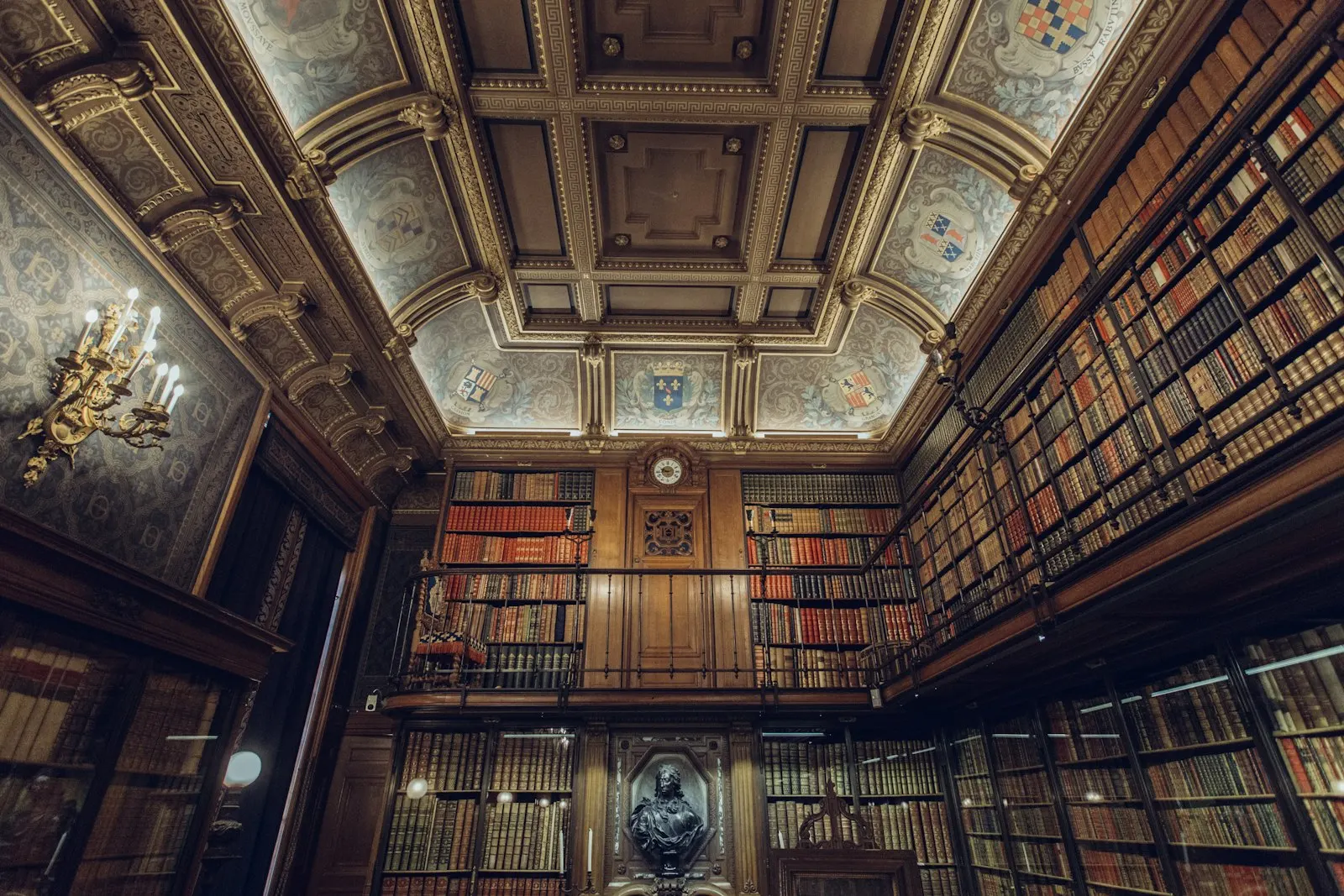 Historischer Bibliothekssaal mit Holzregalen bis unter die verzierte Decke