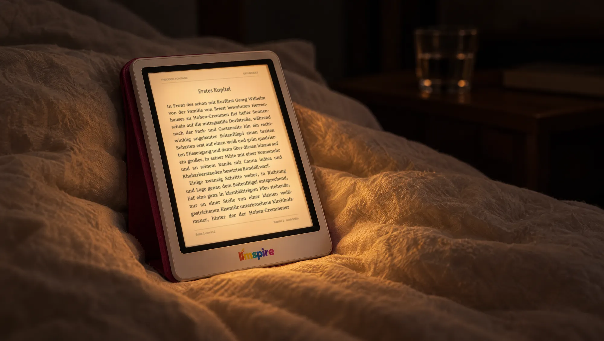 limspire E-Reader mit warmem Frontlicht, angelehnt an eine Bettdecke in einem dunklen Schlafzimmer
